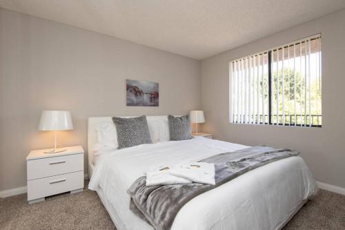 a white bedroom with a white bed and a window at Prime Location 1-Bedroom with Pool in Los Angeles
