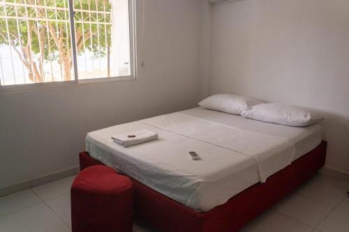 a small bedroom with a bed with a window at HOSTAL PERLA DE TAGANGA in Taganga