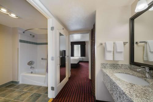 uma casa de banho com uma banheira e um lavatório e uma banheira em Best Western Salinas Valley Inn & Suites em Salinas