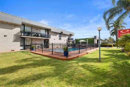 - un bâtiment avec une piscine dans une cour dans l'établissement Econo Lodge Mildura, à Mildura