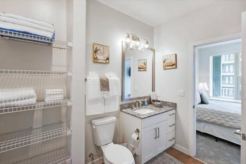 a bathroom with a toilet and a sink and a mirror at New Jax City Rooftop Pool in Jacksonville
