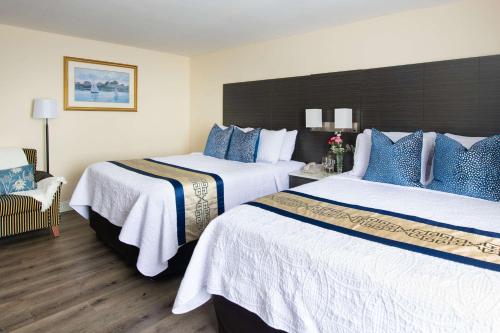 a hotel room with two beds and a chair at Rodeway Inn in Middletown