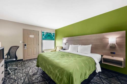 um quarto de hotel com uma cama e uma parede verde em Quality Inn em Jackson