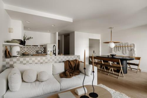 a living room with a white couch and a kitchen at Ski-in/Ski-out Intentionally Designed Ski Lodge in Whistler