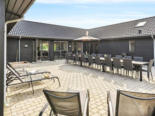a patio with a bunch of chairs and tables at Luxury Beach Retreat - By Traum Ferienwohnungen in Sarup