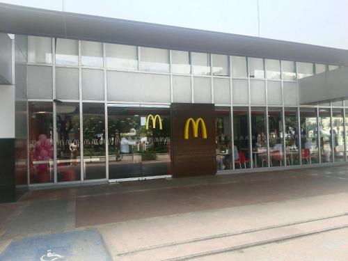 a mcdonalds restaurant with a sign in front of a building at The Mactan Newtown in Punta Engaño