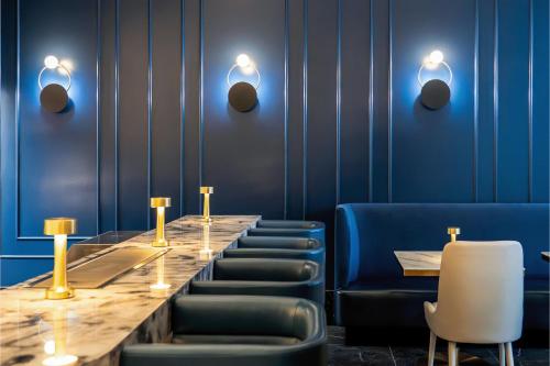 a dining room with a long table and blue chairs at AZUR Legacy Collection Hotel in Vancouver