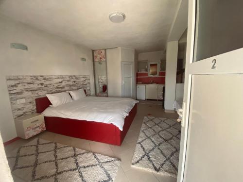 a small bedroom with a bed and a kitchen at Vila Ivan in Berovo