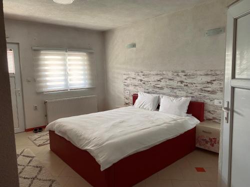 1 dormitorio con 1 cama grande y pared de ladrillo en Vila Ivan, en Berovo