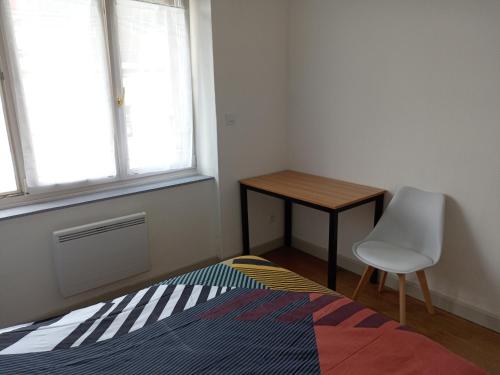 1 dormitorio con cama, escritorio y silla en Appartement paisible - cœur de ville, en Le Creusot