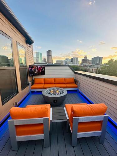 a balcony with orange chairs and a fire pit at Downtown Denver Smart House in Denver
