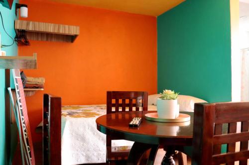 une salle à manger avec un mur orange et vert dans l'établissement Sensity Home Recámara amplia y muy céntrica, à Tehuacán
