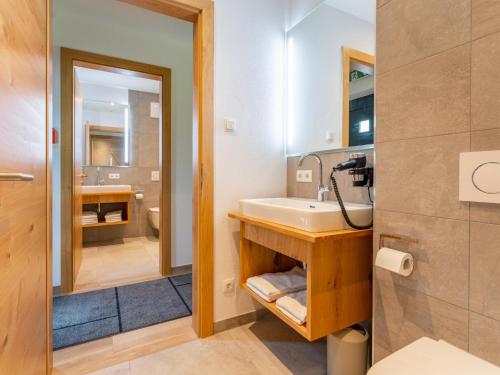 a bathroom with a sink and a mirror at Pinzgau Lodge 1A in Wald im Pinzgau