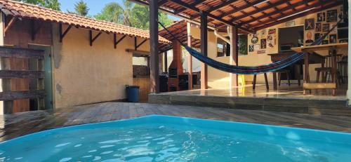 a hammock on the deck of a house with a swimming pool at Casa Canastra in Vargem Bonita