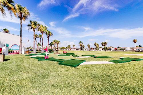 a row of green tarps in a field with palm trees at Long Island Village 502 Clam in Port Isabel