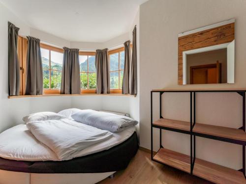 Bett in einem Zimmer mit Spiegel und Fenstern in der Unterkunft Hinterlengau in Saalbach-Hinterglemm