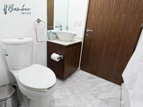 a bathroom with a white toilet and a sink at Amazing City Views Condesa Roma By Bamboo Skylife in Mexico City