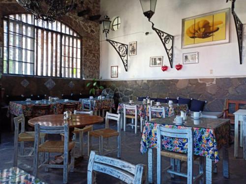 a dining room with tables and chairs and windows at Posada de las Monjas in San Miguel de Allende