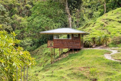 a house on a hill with a roof on it at Hotel Rivel - Restaurant & Nature Retreat in Turrialba