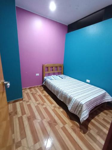 a bedroom with purple and blue walls and a bed at O'cala House 2.0 in Huánuco