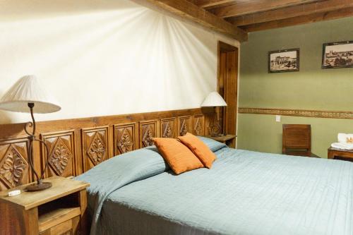 1 dormitorio con 1 cama con sábanas azules y almohadas de color naranja en Hotel CasaMia en Dolores Hidalgo