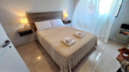 een slaapkamer met een bed met twee handdoeken erop bij Alojamientos Litoral - Dpto España II in Gualeguaychú