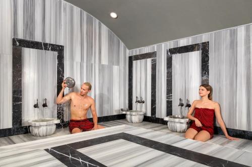 a man and a woman in a bathroom with sinks at Hotella Resort & Spa in Belek