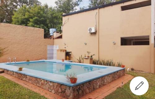 ein Schwimmbad in einem Hof neben einem Haus in der Unterkunft Casa de 4 habitaciones con piscina en barrio cerrado a 5 minutos del Aeropuerto Internacional in Luque