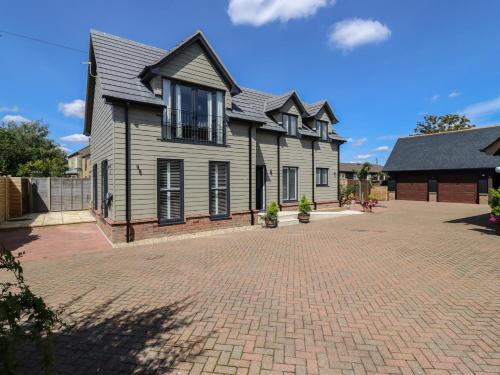 a house with a brick driveway in front of it at Wellington Cottage in Ely