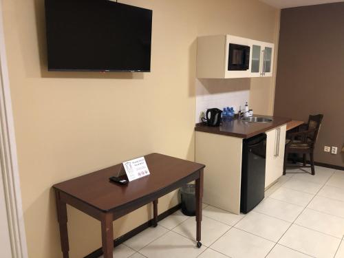 a room with a table and a kitchen with a sink at 101 Suites in Paramaribo