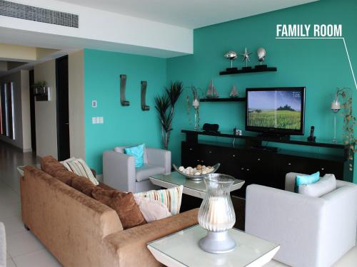 a living room with a couch and a tv at Icon Vallarta Beach front By Bamboo Skylife in Puerto Vallarta