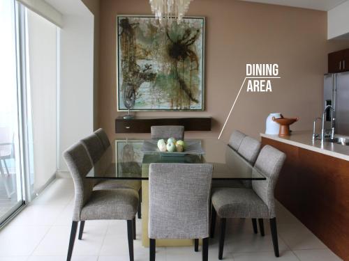 a dining room with a glass table and chairs at Icon Vallarta Beach front By Bamboo Skylife in Puerto Vallarta