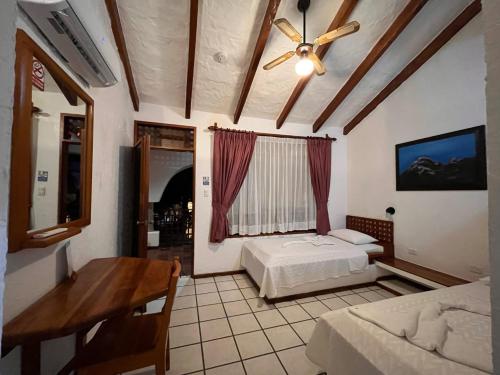 a bedroom with a bed and a table and a window at Hotel Silberstein in Puerto Ayora