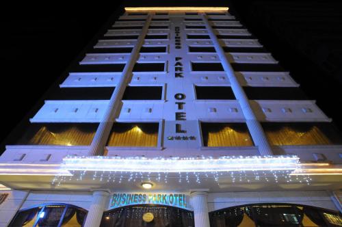 a tall white building with a lit up sign at Business Park Hotel in Ankara