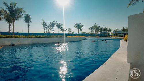 a swimming pool with palm trees and people in it at Crissome Suite Azure North San Fernando Pampanga in Lagundi