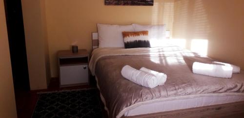 a bedroom with a bed with white sheets and pillows at Villa Boho Cherga in Belgrade