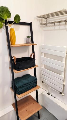 - une étagère avec des serviettes vertes dans un placard dans l'établissement Levalet BNB - La Défense, à Courbevoie