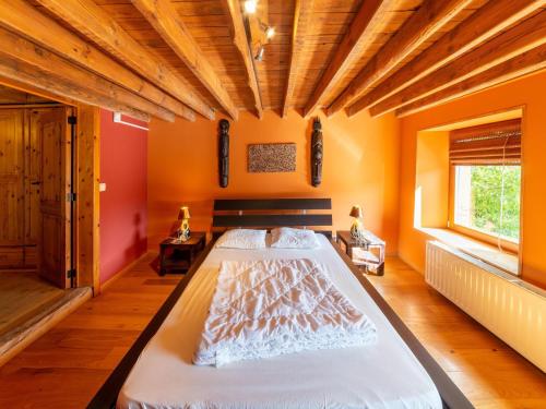 a large bed in a room with orange walls at Holiday home situated in a rural setting in Lierneux