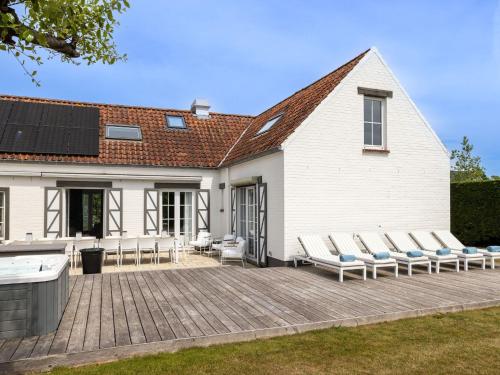 聖伊達斯拜的住宿－Luxury Villa in Sint Idesbald with Jacuzzi，一个带躺椅的庭院和一座房子
