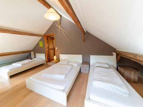 1 dormitorio en el ático con 2 camas y techo en Quaint Holiday Home near Forest in Lierneux en Lierneux