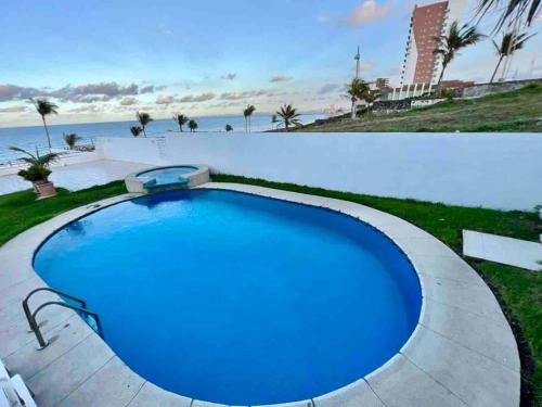 a large blue swimming pool with the beach in the background at Sexto piso y vista al mar in Boca del Río