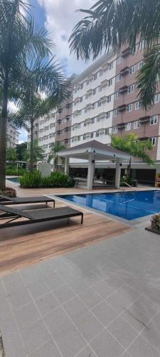 a hotel with a swimming pool and a large building at Auberge Condotels at SMDC Hope Residences in Trece Martires