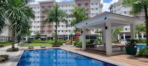 a hotel pool with a gazebo and a building at Auberge Condotels at SMDC Hope Residences in Trece Martires