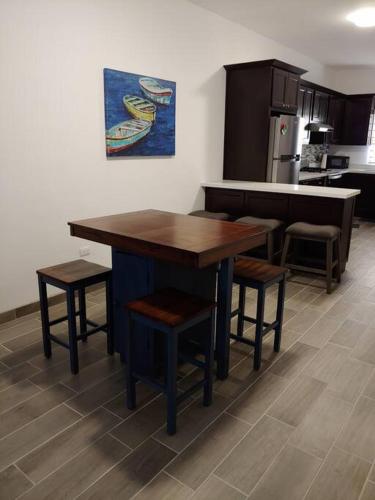 a kitchen with a wooden table and some stools at Casa 337 -New home with garage & community pool in Puerto Peñasco