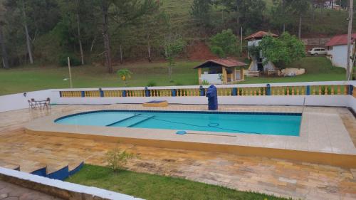 a large swimming pool with a fence around it at Fascinação Café Hotel in Cunha