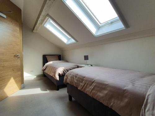 - 2 lits dans une chambre avec 2 fenêtres dans l'établissement Luxury Family Holiday Home with Wellness, à Binsfeld