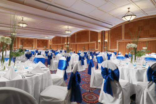 a banquet hall with white tables and blue bows at Sheraton Skyline Hotel London Heathrow in Hillingdon