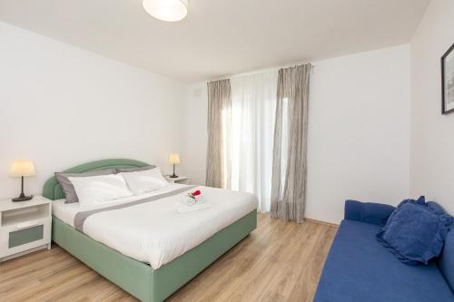 a bedroom with a bed and a blue couch at Apartments and rooms with parking space Njivice, Krk - 17010 in Njivice