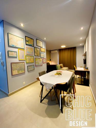 ein Esszimmer mit einem Tisch und einer blauen Wand in der Unterkunft Chic Blue Design com Vaga de Garagem in São Paulo
