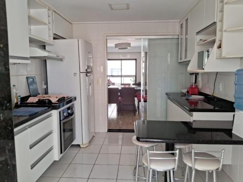 a kitchen with white appliances and white cabinets at Apartamento na Praia do Morro -160 metros da praia -Ar condicionado e internet -Perto de tudo in Guarapari